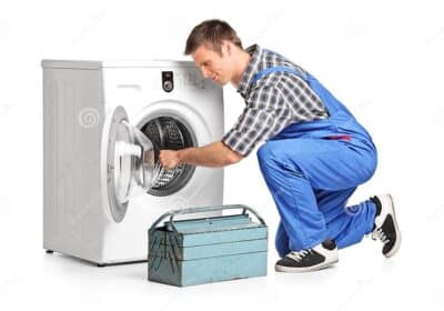 young-plumber-fixing-washing-machine-white-background-41437170