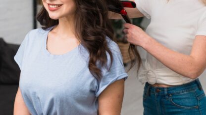 stylist-curling-hair-young-woman-1