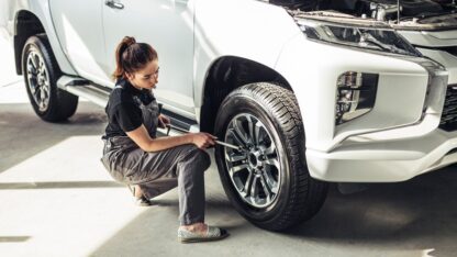 high-angle-female-mechanic-taking-out-wheel_23-2148327578