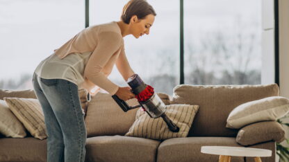 young-woman-with-rechargeable-vacuum-cleaner-cleaning-home-1